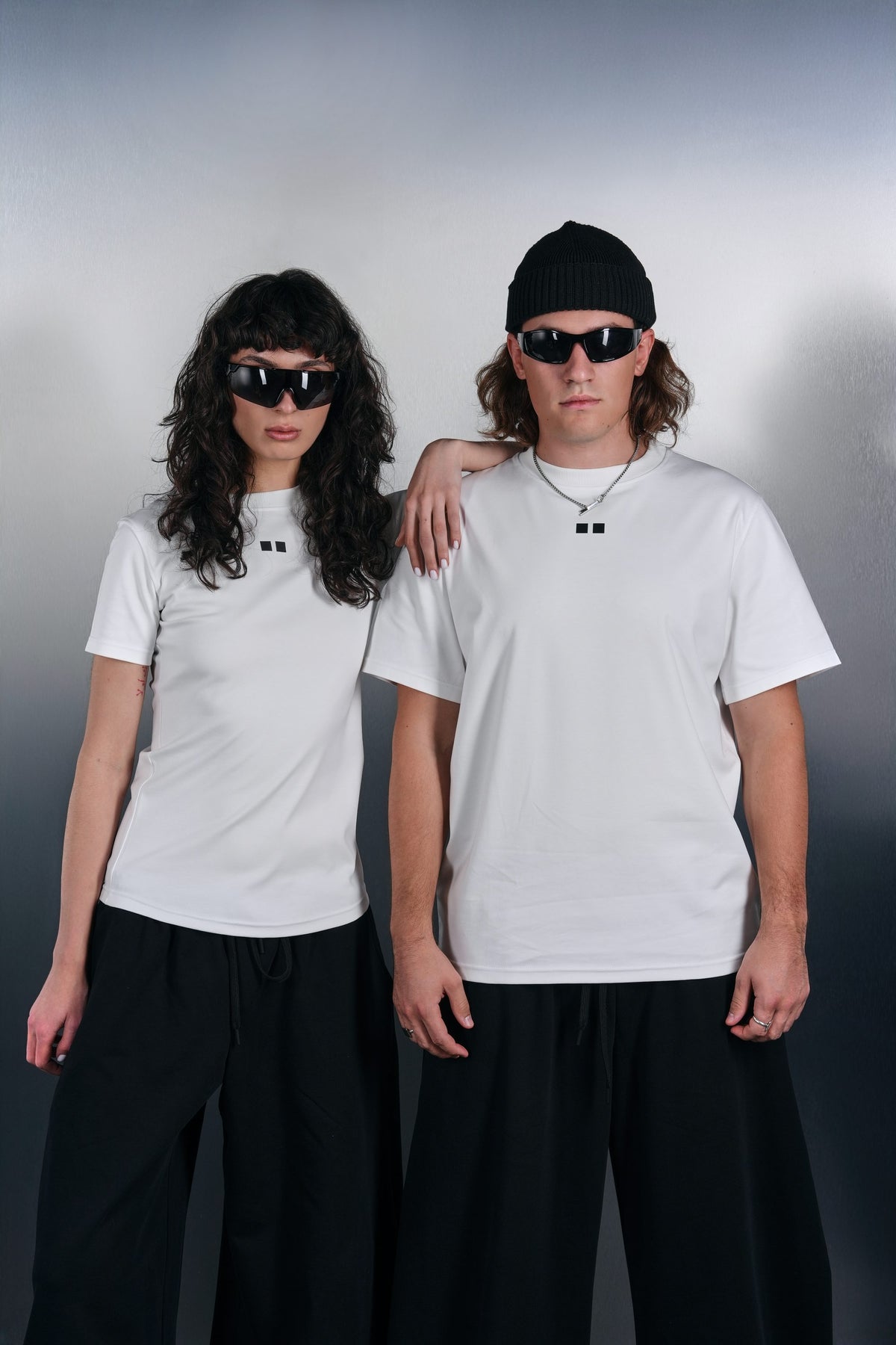 White KYN T-shirts, oversized and fitted, with black trousers