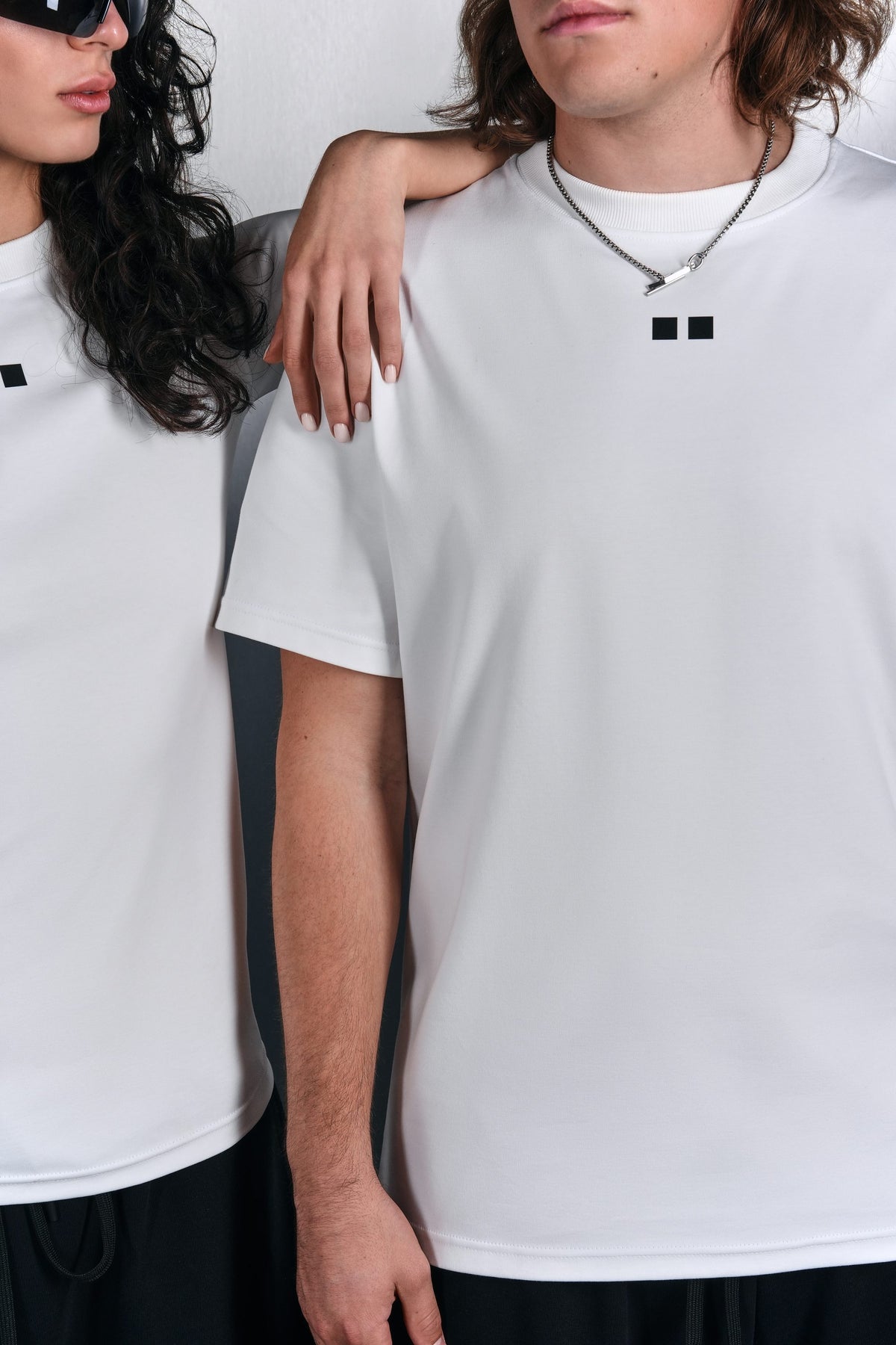 Close-up: white KYN T-shirts with the two-square logo