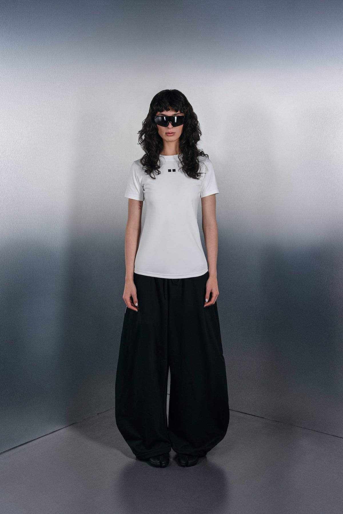 White fitted KYN T-shirt and wide black trousers