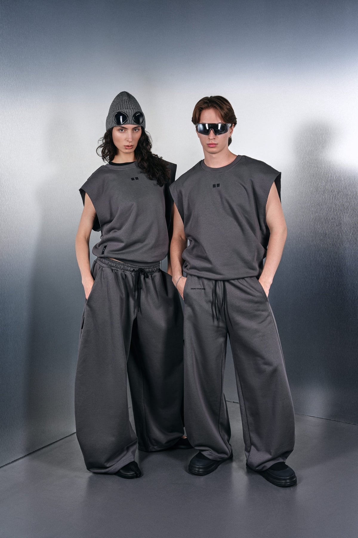 Two grey KYN Drop-Shoulder vests and grey trousers